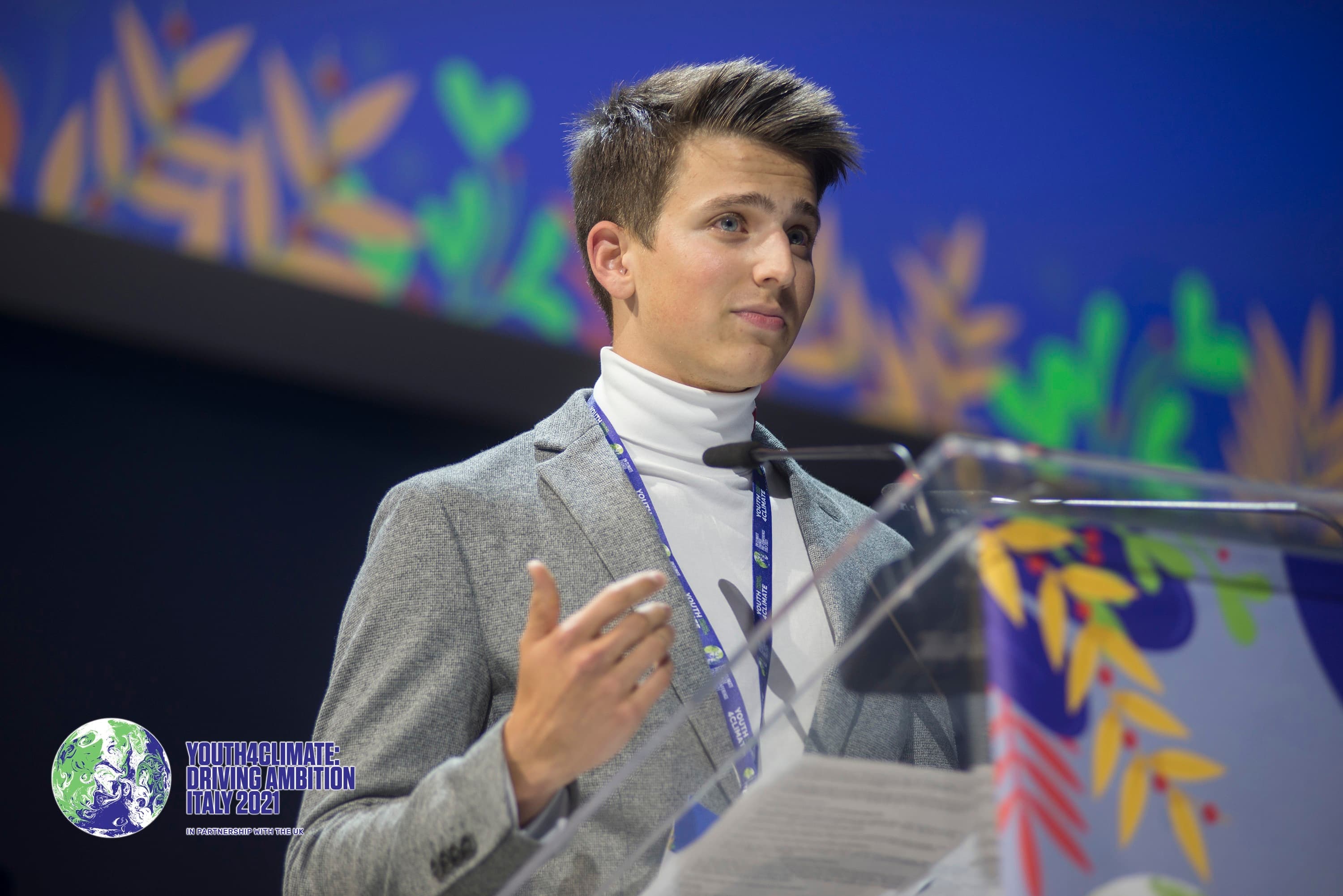 A young changemaker speaking from the podium at Youth4Climate